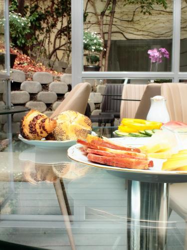 a glass table with two plates of food on it at Milford Suites Budapest in Budapest