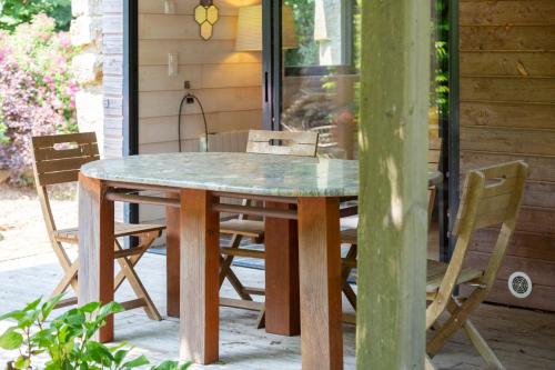 une table et des chaises en bois sur une terrasse dans l'établissement Mousterlin Cottage 4pers 200m plage, à Fouesnant