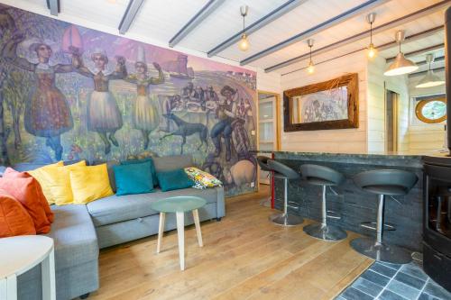 - un salon avec un canapé et une fresque murale dans l'établissement Mousterlin Cottage 4pers 200m plage, à Fouesnant