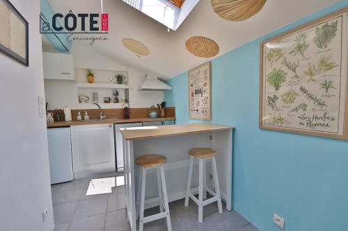 - une cuisine avec un comptoir et des tabourets dans l'établissement Le Petit Mas, à Carry-le-Rouet