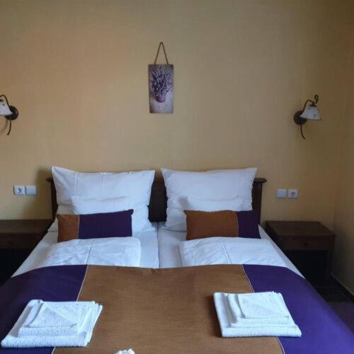 a bedroom with a bed with two towels on it at Thermália Vendégházak - Levendula Apartman in Kaba