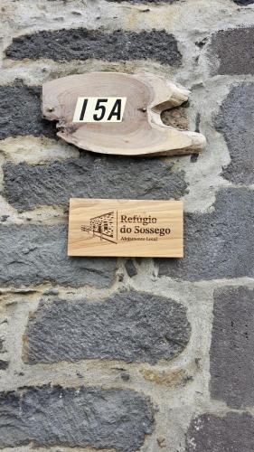 a sign on the side of a stone wall at Refúgio do Sossego in Pedreira
