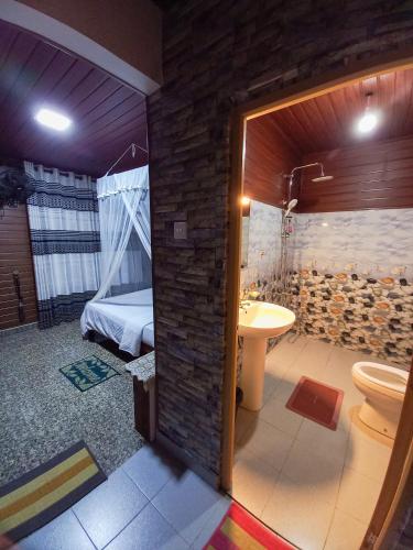 a bathroom with a toilet and a sink and a bed at Ella Happy View Homestay in Ella