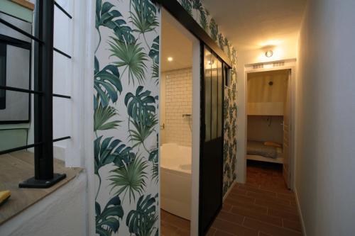 un couloir avec une salle de bain avec des plantes vertes sur le mur dans l'établissement Foc - Original loft Beach - Port, à La Rochelle