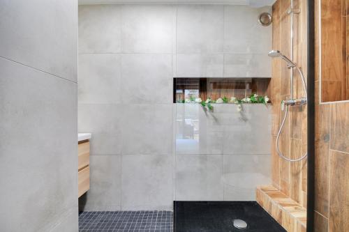 une salle de bain avec une douche avec une porte vitrée dans l'établissement Appartement proche hôpital américain, à Levallois-Perret