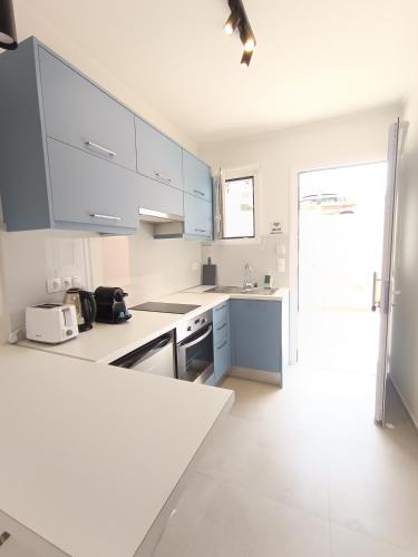 a kitchen with white cabinets and a white counter top at Panorama View in Agios Stefanos