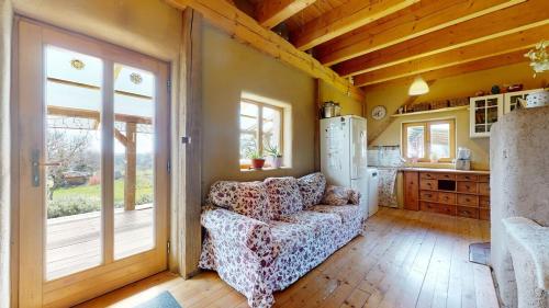 Una sala de estar con un sofá y una cocina. en Slamený dom, en Krupina