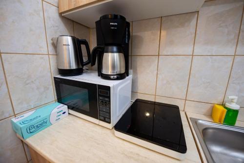 a coffee maker on top of a microwave in a kitchen at Royal Accommodation in Bucharest
