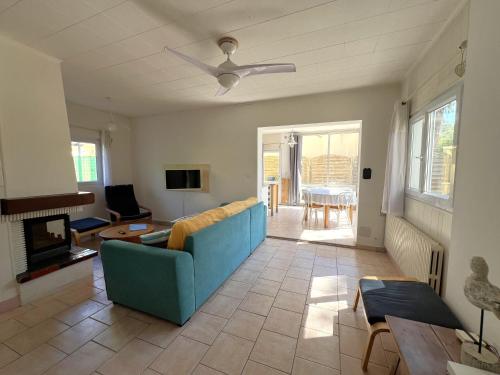 un salon avec un canapé bleu et une table dans l'établissement MISTRAL Appartement T3 pour 4 personnes proche plage de la Capte, à Hyères