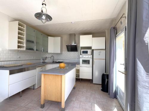une cuisine avec des placards blancs et un îlot. dans l'établissement MISTRAL Appartement T3 pour 4 personnes proche plage de la Capte, à Hyères