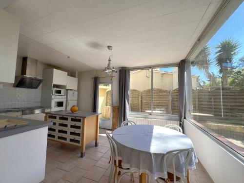 une cuisine avec une table et des chaises dans une pièce dans l'établissement MISTRAL Appartement T3 pour 4 personnes proche plage de la Capte, à Hyères