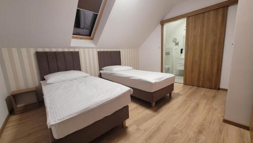 a room with two beds and a tv on the wall at Wiślana 4 in Spytkowice