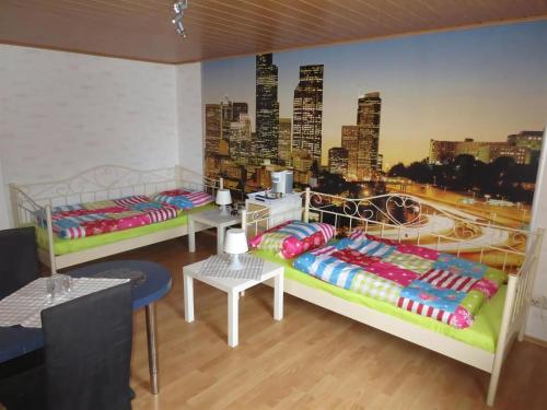 two beds in a room with a mural of a city at Santa Maria in Nettersheim