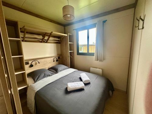 une chambre avec un lit avec deux serviettes dessus dans l'établissement Le Tiny en Baie - WIFI - Exceptionnel, à Mons-Boubert