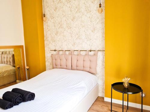 une chambre avec un lit blanc et des murs jaunes dans l'établissement Appartement Prestige, Climatisation, Balcon, Nice, à Nice