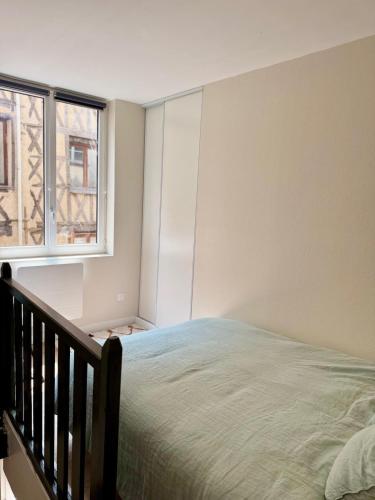 une chambre avec un lit et une fenêtre dans l'établissement Élégant duplex dans le centre historique, à Limoges
