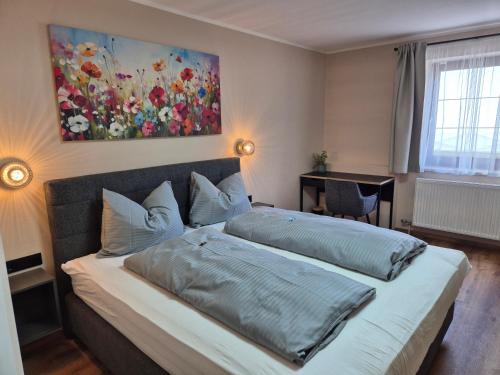 a bedroom with a bed with a painting on the wall at Lindengut Natternbach in Natternbach