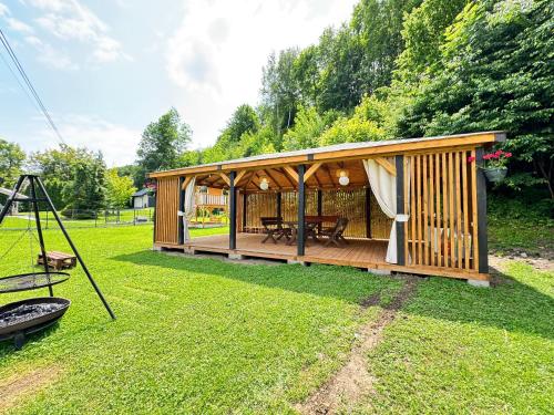 a wooden cabin with a table in the grass at Willa Wioletta in Tylmanowa