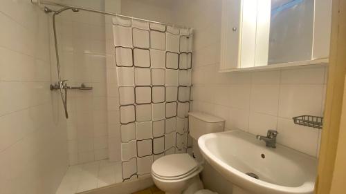 a white bathroom with a toilet and a sink at Barbati Olive in Barbati