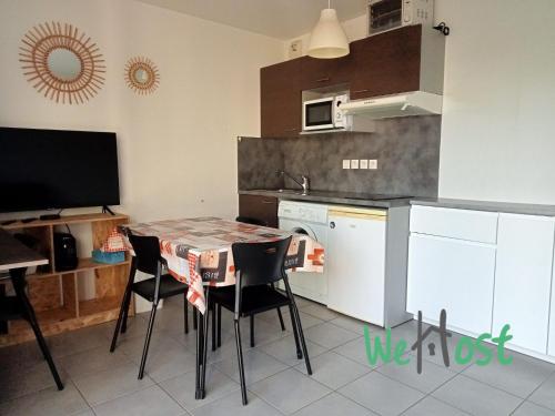 une cuisine avec une table et des chaises dans une pièce dans l'établissement Flora - Studio Proche gare Parking, à La Rochelle