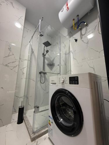 a washing machine in a bathroom with a shower at Thom Tower in Gonio