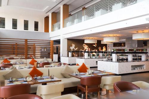 a restaurant with tables and chairs and a bar at Radisson Blu Hotel & Resort, Sohar in Sohar