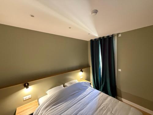 a bedroom with a large bed and a window at Alma Hotel in Courbevoie