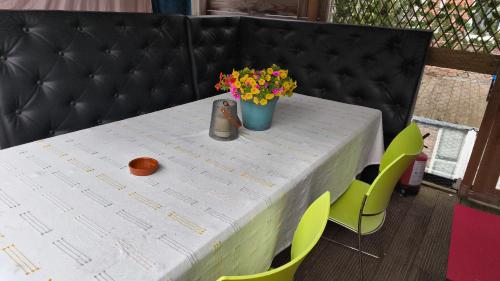 a white table with a vase of flowers and chairs at Happy in Deventer in Deventer