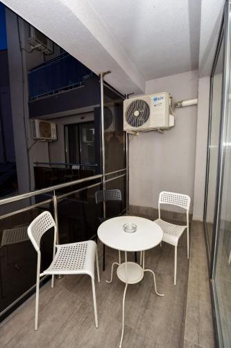a balcony with a table and chairs and a heater at Royal Accommodation in Bucharest