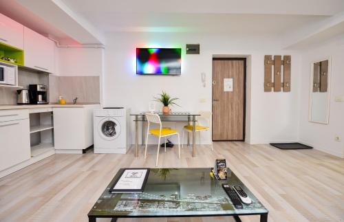 a living room with a table and a kitchen at Royal Accommodation in Bucharest