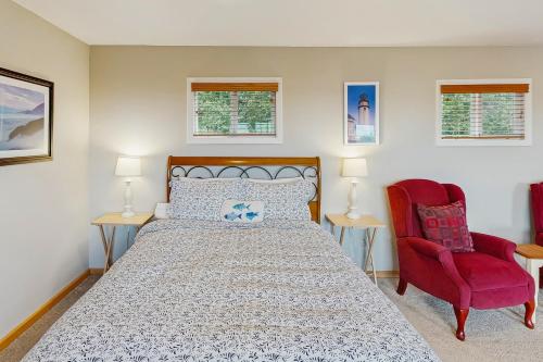 a bedroom with a bed and a red chair at Harbor View Studio Cottage in Gold Beach