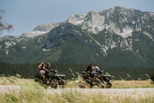a group of people riding motorcycles on a mountain road at Pinelle Blidinje A-Frame House in Risovac