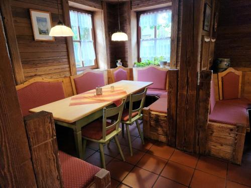 a dining room with pink chairs and a table at Landgasthof Hummel in Ebensfeld