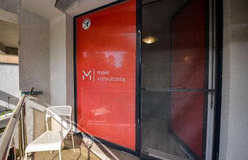 a red door on a building with a white chair at Royal Accommodation in Bucharest