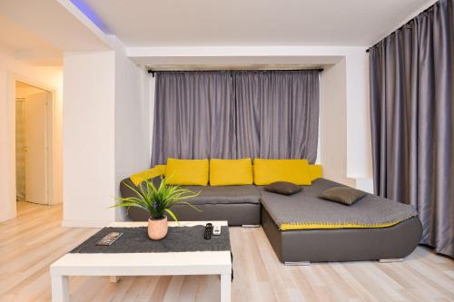 a living room with a couch with yellow pillows at Royal Accommodation in Bucharest