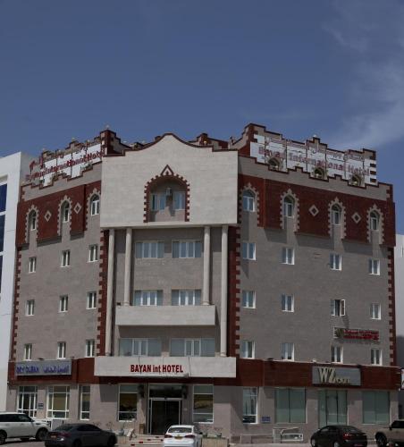 a large building with cars parked in front of it at Bayan International Hotel in Mawāliḩ