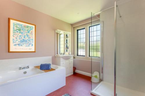 une salle de bain avec une douche, une baignoire et un lavabo dans l'établissement Greenhill Cottage Sea Views with Thatched Charm, à Beer