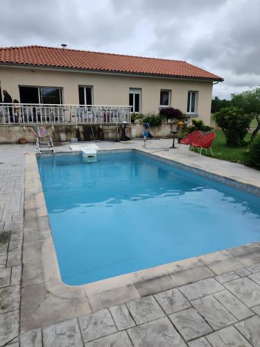 une grande piscine bleue devant une maison dans l'établissement Maison Zoé- Haute pyrenees, à Saint-Laurent-de-Neste