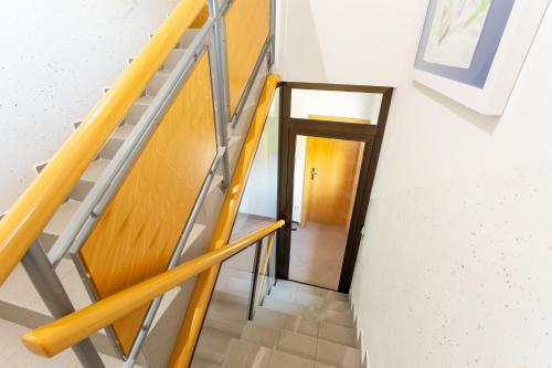 a staircase leading to a hallway with a wooden door at Apartment in the Village in Petrovče
