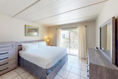 a bedroom with a bed and a large window at Fiesta Sol Condominiums 212 in South Padre Island