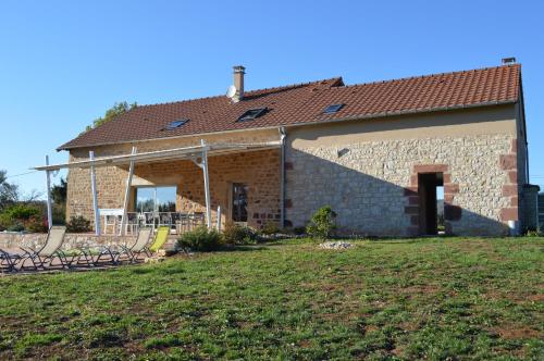 une maison en briques avec une cour devant elle dans l'établissement La maison du Romarin, à Meyssac