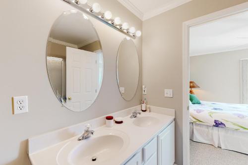 a bathroom with a sink and a mirror and a bed at Bethany Marina ---37845 Salt Grass Cove #92 in Ocean View