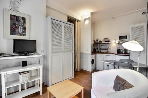 un salon avec une télévision, un canapé et une table dans l'établissement Parisian Home I S04308 I Marais, à Paris