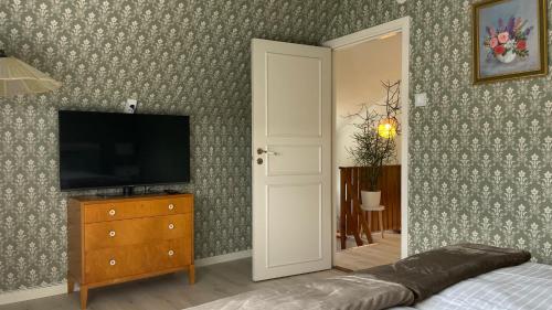 a bedroom with a television and a bed and a dresser at Villa ASTRID PremiumFerienhaus inkl Bettwäsche Handtücher in Storebro