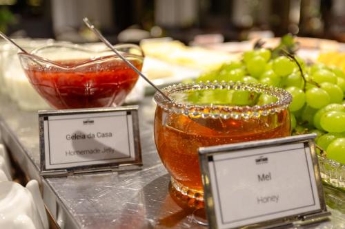 a table with a bowl of liquid and a bowl of grapes at Iconyc Charlie Ibirapuera Hotel in Sao Paulo
