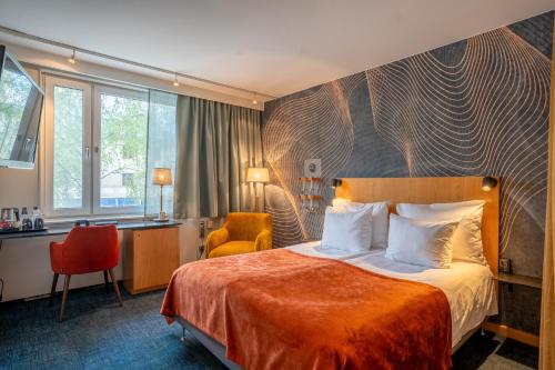 a hotel room with a bed and a desk at ProfilHotels Aveny in Umeå