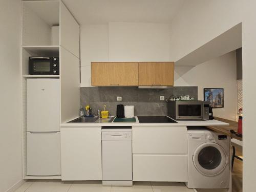 une cuisine blanche avec une machine à laver et un micro-ondes dans l'établissement The Artist - Hypercentre, à Grenoble