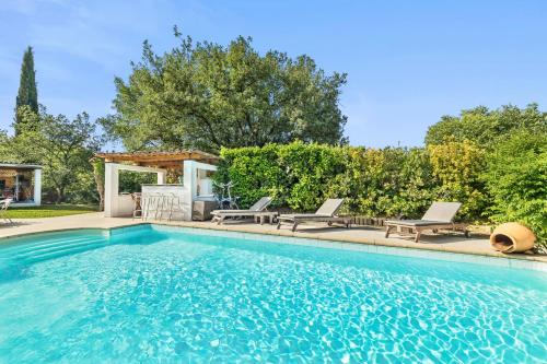 - une piscine avec 2 chaises longues et une maison dans l'établissement Villa climatisée, piscine privée chauffée, Fitness proche Cannes, Fréjus, St Raphael, Grasse, à Montauroux
