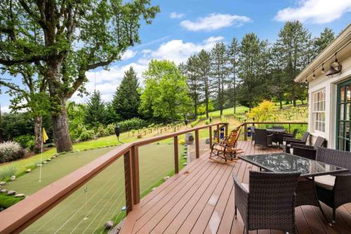 a wooden deck with a table and chairs on it at Hoffman Woods Estate in West Linn