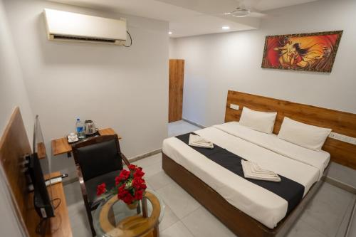a bedroom with a bed and a chair in it at Hotel Vaishnavi Classic in Secunderabad